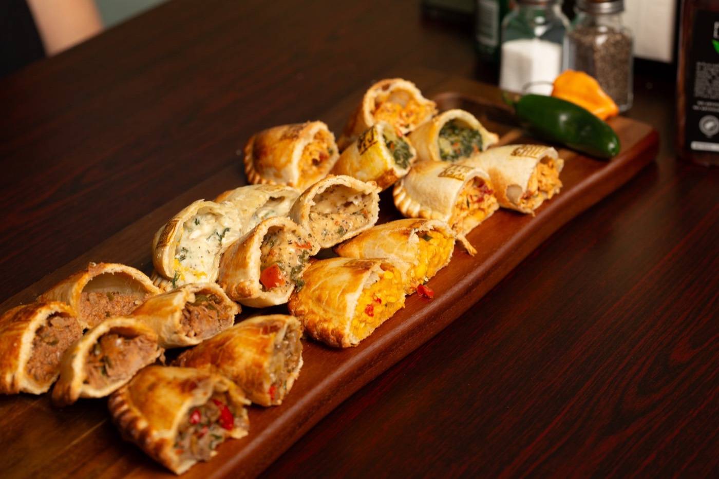 Empanadas cut open on a board, showing every filling