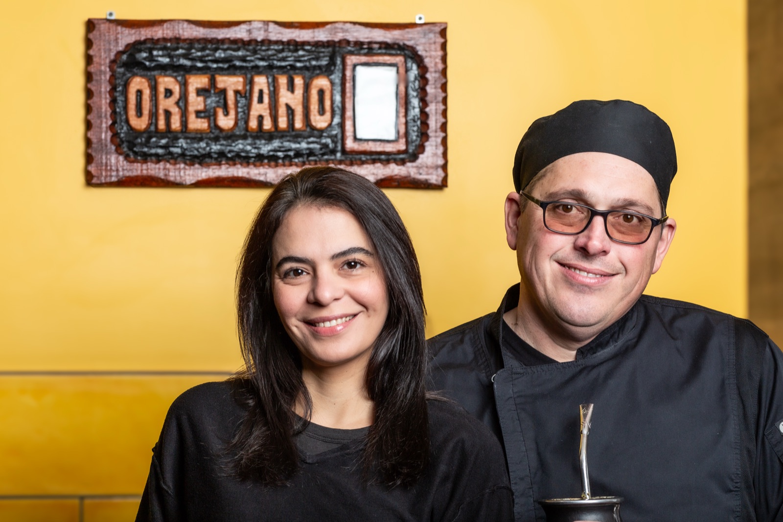 The owners of Orejano beneath the carved Orejano sign